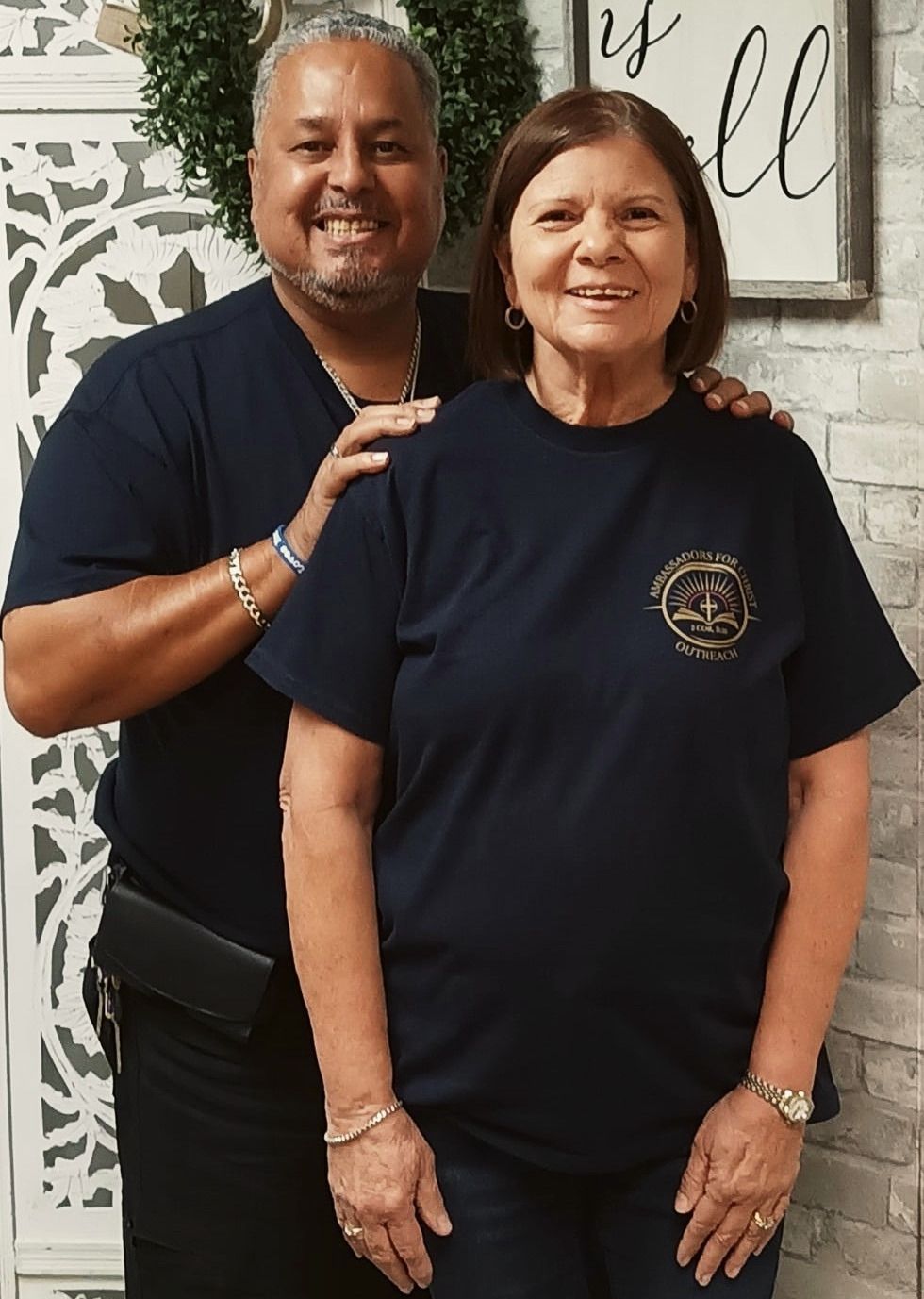 Rick and Donna Fernandez, founders of AFCO 5:20, standing together with his hand on her shoulder; the AFCO 5:20 emblem is embroidered on her shirt.